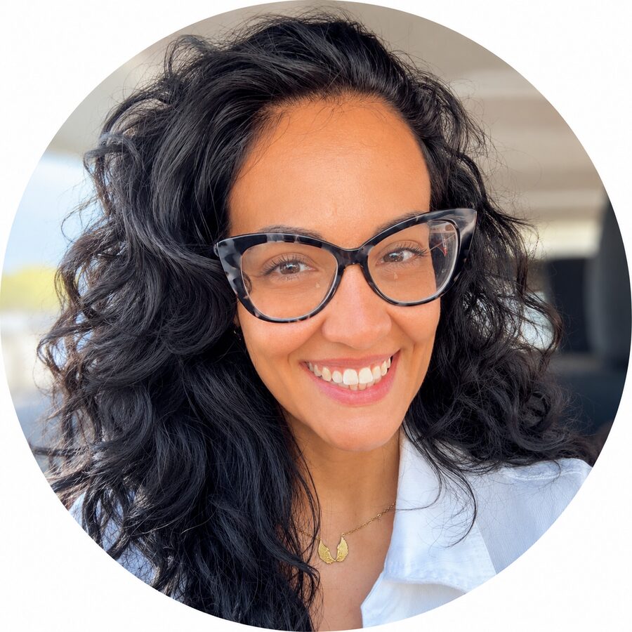 Retrato de Cristina Ramírez sonriendo, con gafas y camisa blanca